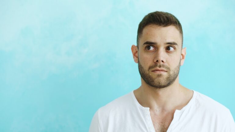 Man looking away from camera on blue background